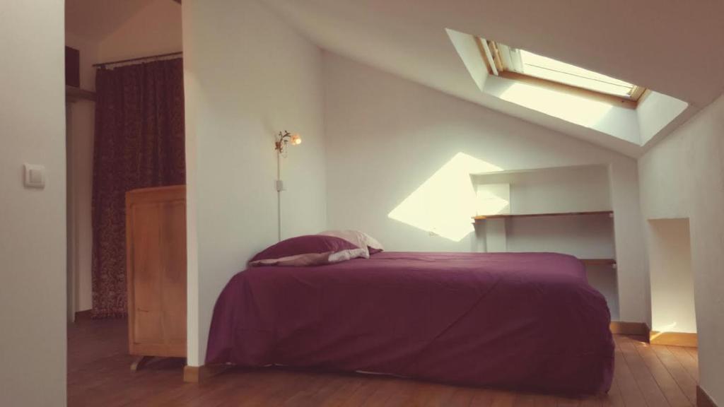 - une chambre avec un lit et une couverture violette dans l'établissement Appartement Corse Extrême-Sud, à Monacia-dʼAullène