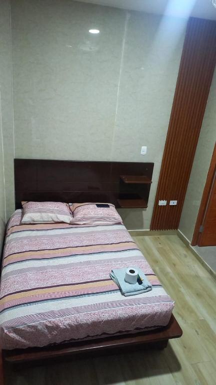 a bed with a pair of shoes sitting on it at Hospedaje Mi Casita - Pucallpa -Selva in Puerto Callao