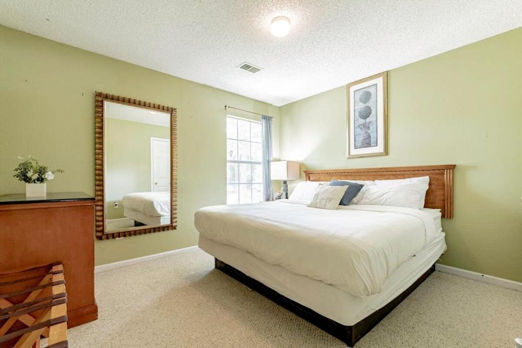 1 dormitorio con 1 cama grande y espejo en Aerie Oaks Cottage-5min to Lake, 20min to Columbia, en Lexington