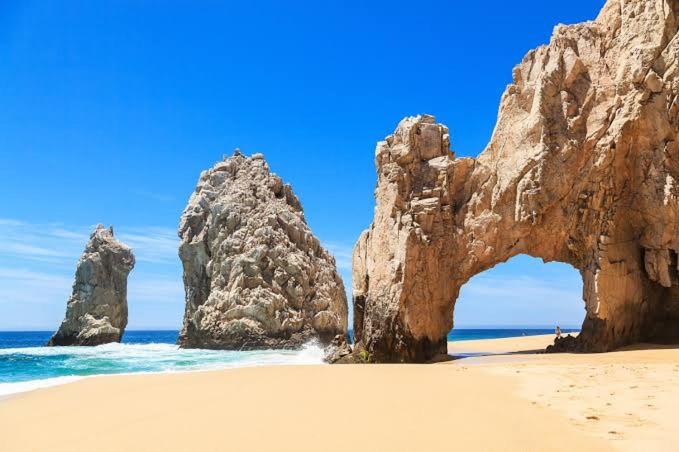 an arch in a rock formation on a beach at Marina Junior suite in Cabo San Lucas