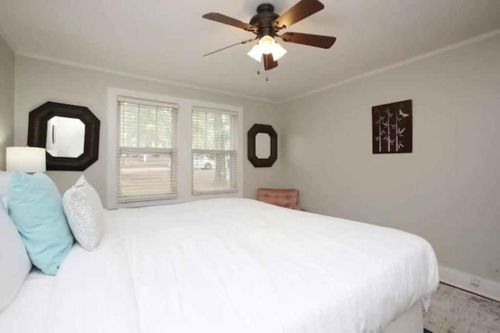1 dormitorio con cama blanca y ventilador de techo en Forest Lake Hidden Gem 3 Min to Ft Jackson & Shops en Columbia
