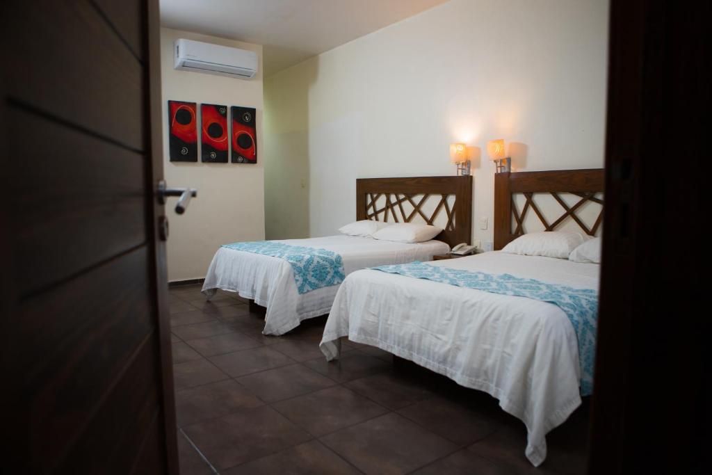 Cette chambre comprend 2 lits avec des draps blancs. dans l'établissement Hotel Tres Soles, à Ciudad Madero