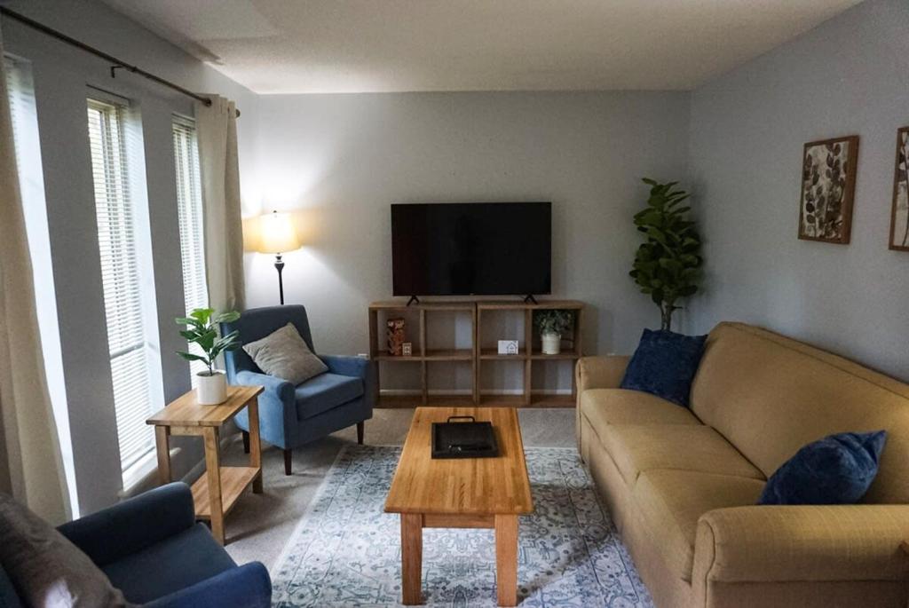 ein Wohnzimmer mit einem Sofa und einem TV in der Unterkunft Mins to River Mountain Park Dining & Shopping in Little Rock