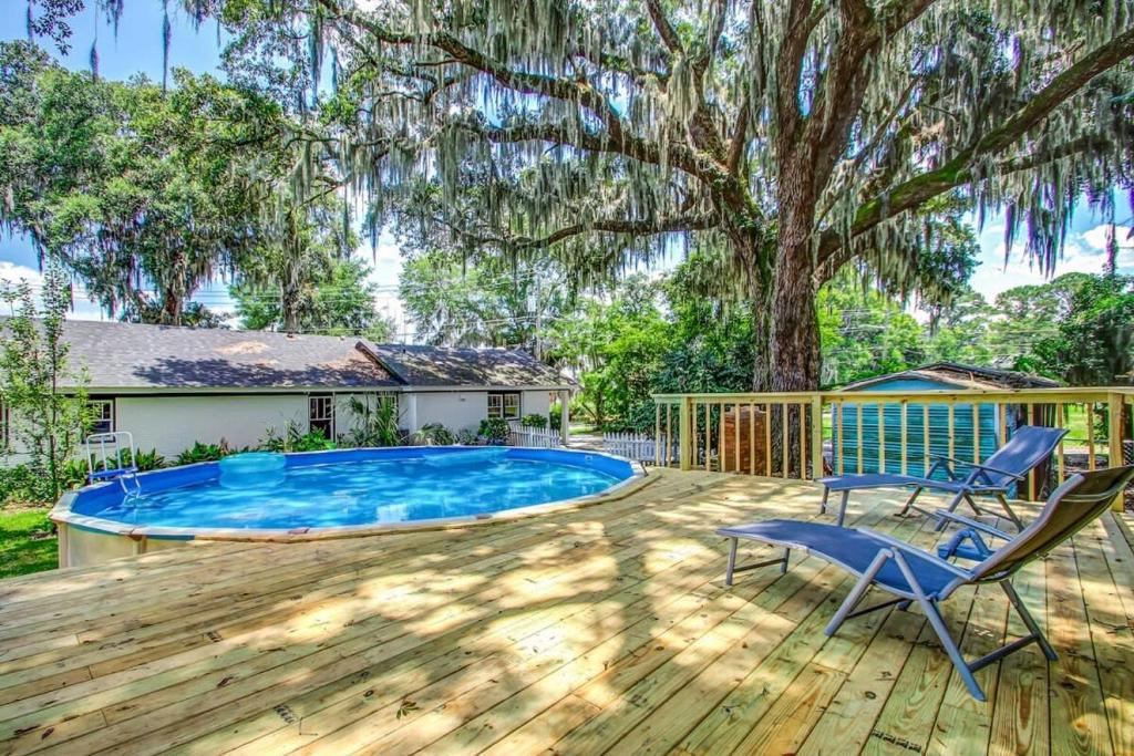 a deck with a swimming pool and two chairs at Studio with Gazebo-Swanky Savannah Style in Savannah
