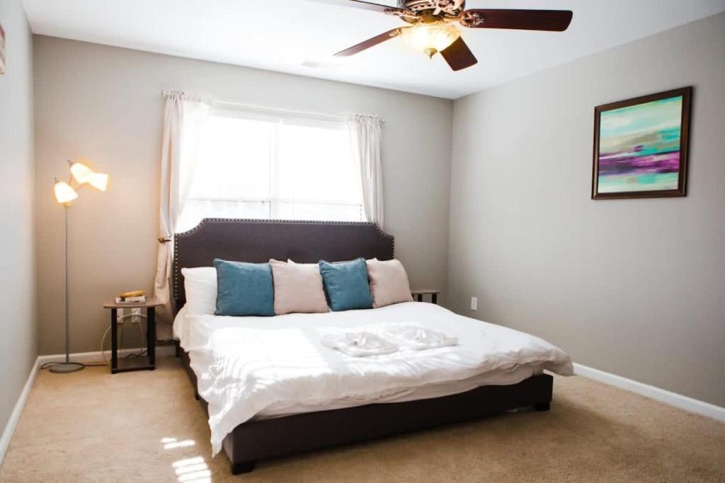 a bedroom with a bed with a ceiling fan and a window at The Lucky Charm Sunny Screened Porch Near USC&Base in Columbia