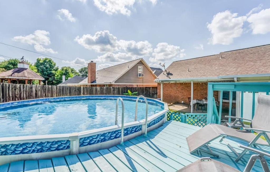 a swimming pool with a wooden deck and a house at Fenced Yard - Comfy & Convenient in Cordova in Memphis