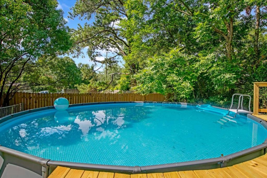 una gran piscina con terraza de madera y valla de madera en Midcentury Modern - Pool & Hot tub - Retro Retreat en Mobile