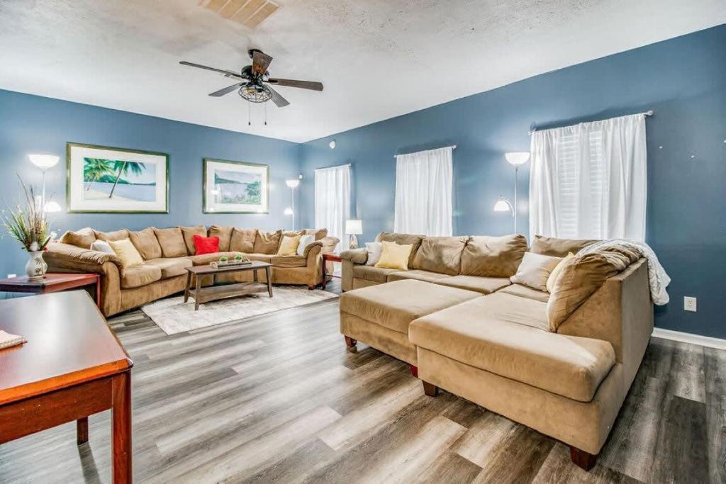 a living room with couches and a ceiling fan at Cam's Coastal Cottage- NAS Pensacola, Close to Beach in Pensacola