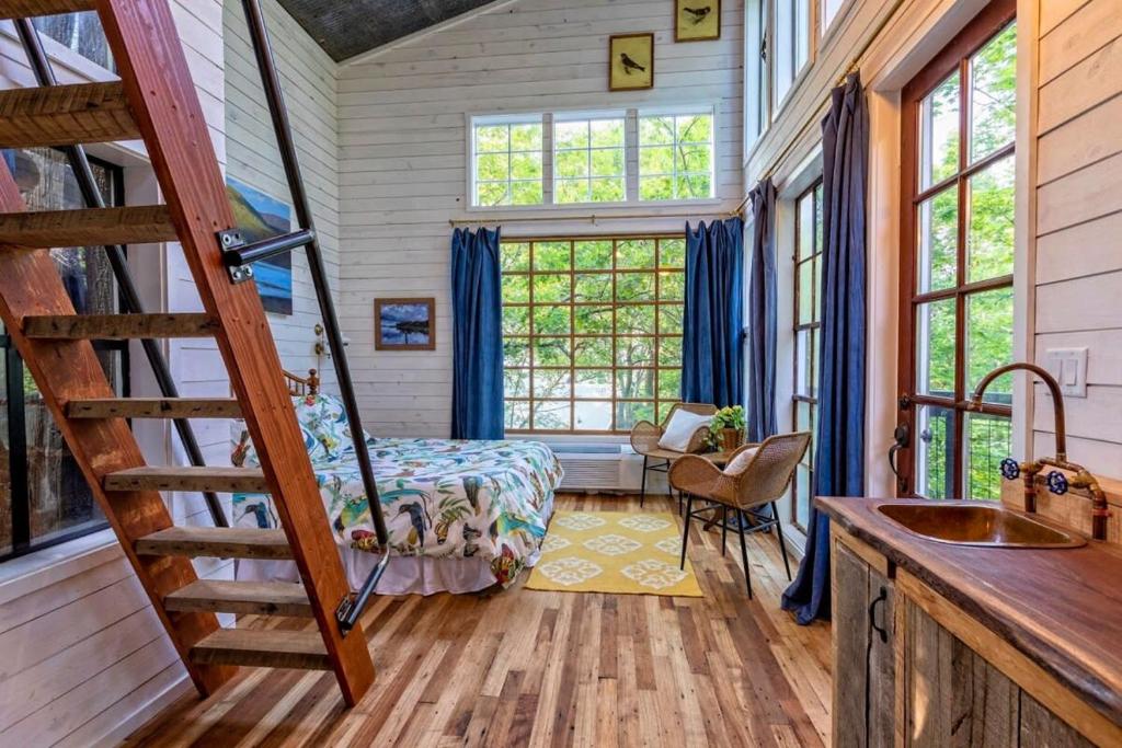 a bedroom with a bed and a staircase in a house at Treetop Hideaways: The Dogwood Treehouse in Chattanooga