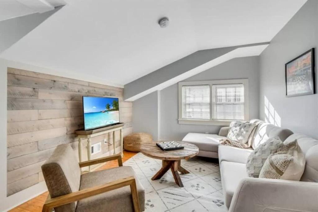 een woonkamer met een witte bank en een tv bij Covered in Sunshine in Midtown Augusta in Augusta
