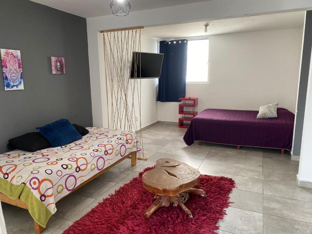 a bedroom with two beds and a red rug at Hospedaje Feria de San marcos 2024 Para 8 Personas in Aguascalientes
