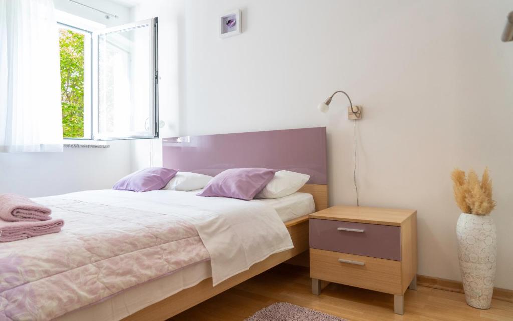 1 dormitorio con cama y ventana en Apartments Lila en Cres