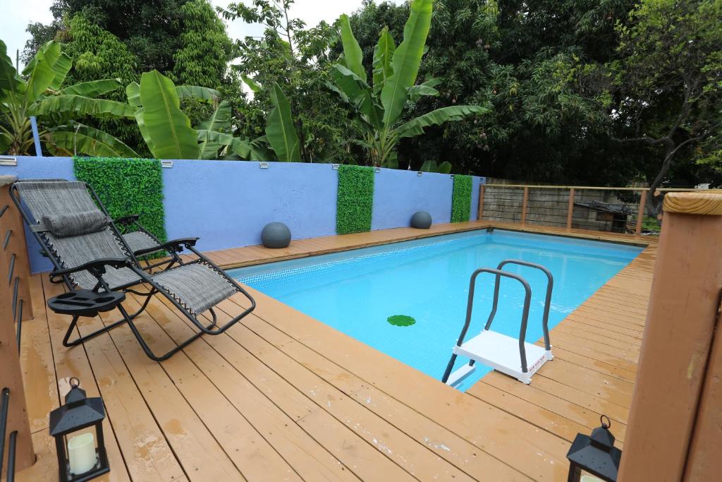 a deck with a swimming pool and two chairs at Home Away From Home in Kingston