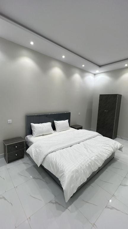 a bedroom with a large bed with white sheets at منتجع لي فارد in Taif