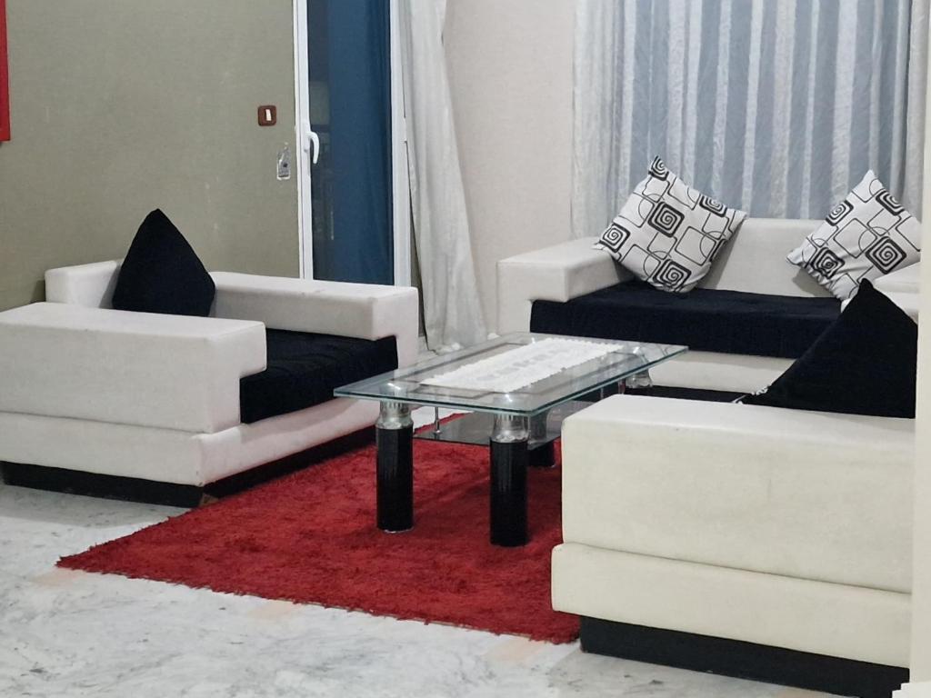 sala de estar con 2 sofás blancos y mesa de cristal en Panorama III Cliniques les Jasmins en Ariana
