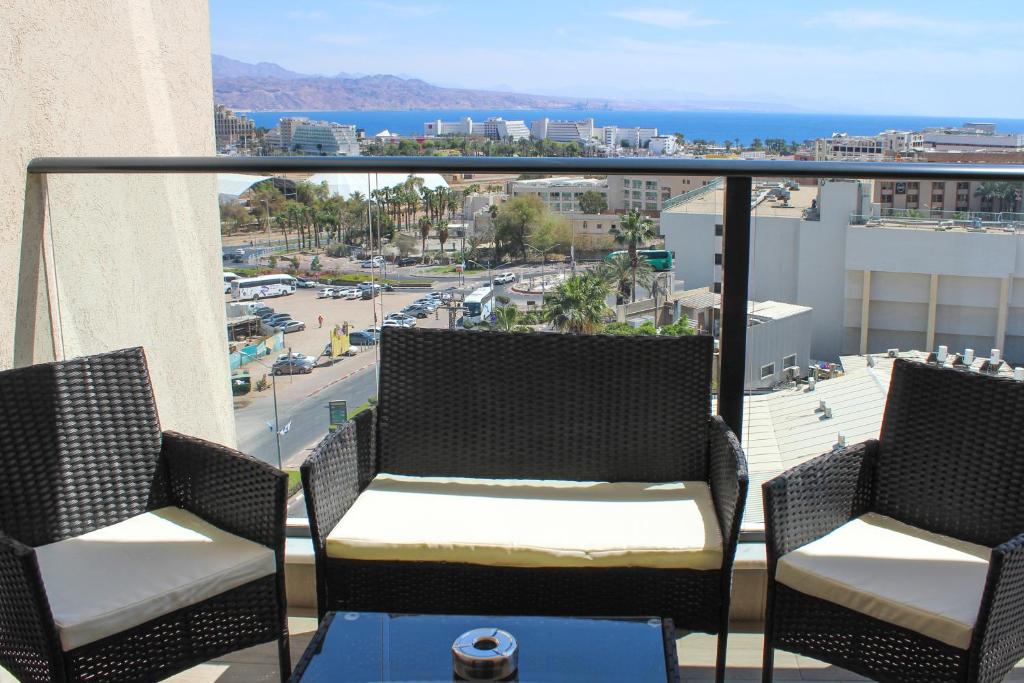 埃拉特Luxury Suite Apartment With Sea View #53 By Hashdera Eilat的带椅子的阳台，可欣赏城市景观