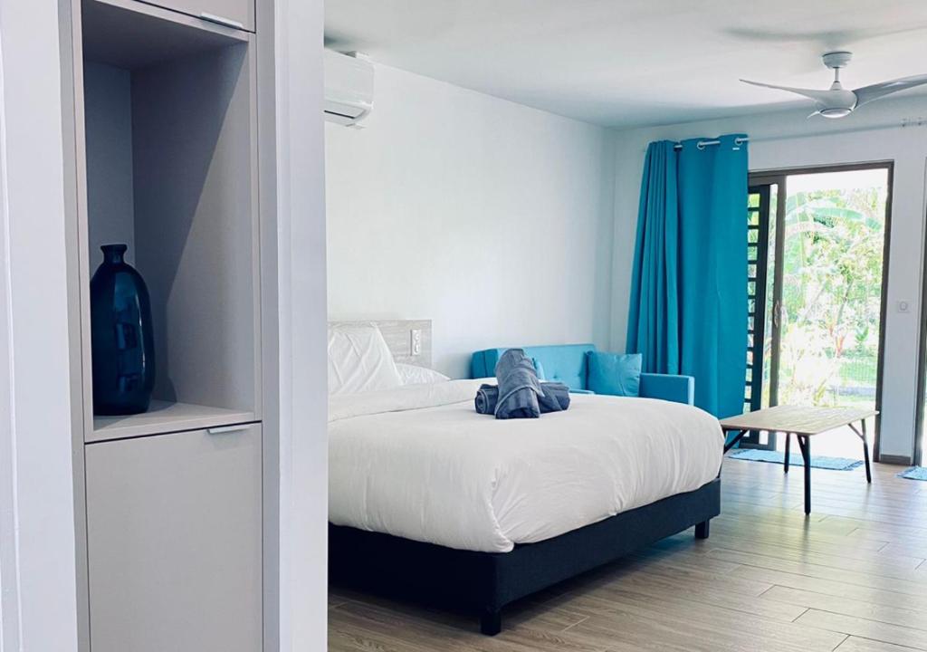 1 dormitorio con cama y cortina azul en Mareta Lodge - Studio MAHA 4 en Bora Bora