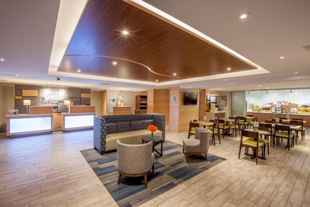 um átrio do hotel com um restaurante com mesas e cadeiras em Holiday Inn Express Hotel & Suites Saint John Harbour Side, an IHG Hotel em Saint John