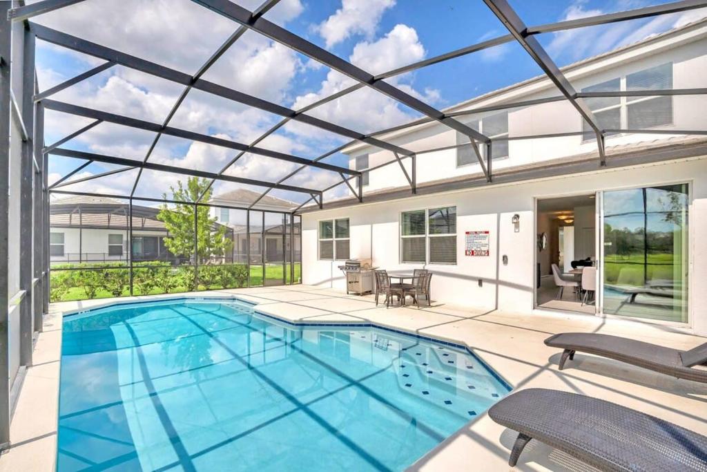 una grande piscina con soffitto in vetro di Family Resort - 6BR Mansion - Private Pool, Home Theater, BBQ and More a Kissimmee