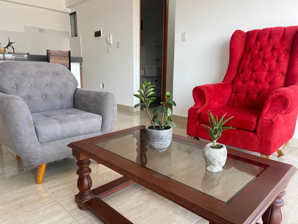 a living room with two chairs and a coffee table at Departamento 401 - NAREA in Pimentel