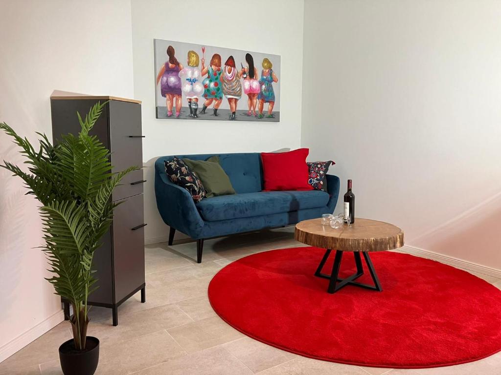 sala de estar con sofá azul y alfombra roja en Landperle 2, en Ulsnis