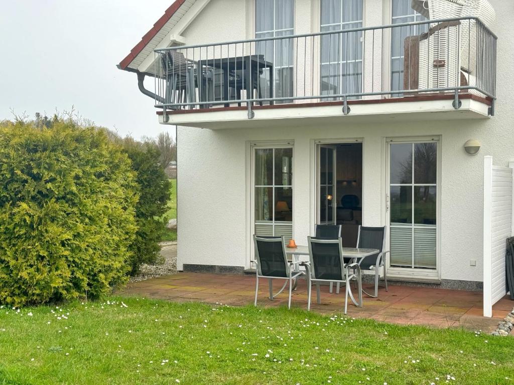 Cette maison dispose d'une terrasse avec une table et des chaises. dans l'établissement Neddesitz - Fewo 263, à Sagard