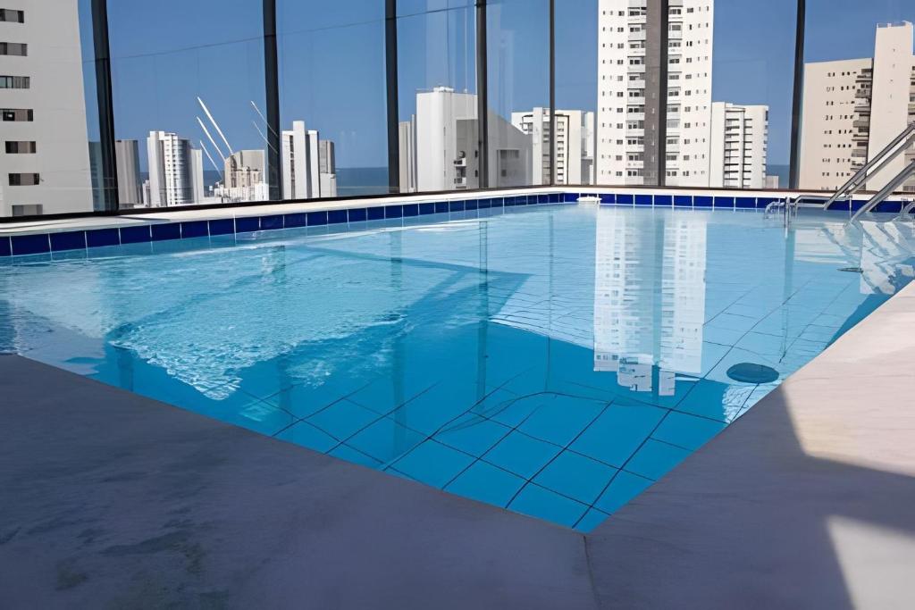 uma piscina com um horizonte urbano ao fundo em Hosts BR - Studio Funcional em Boa Viagem(s/taxas) no Recife