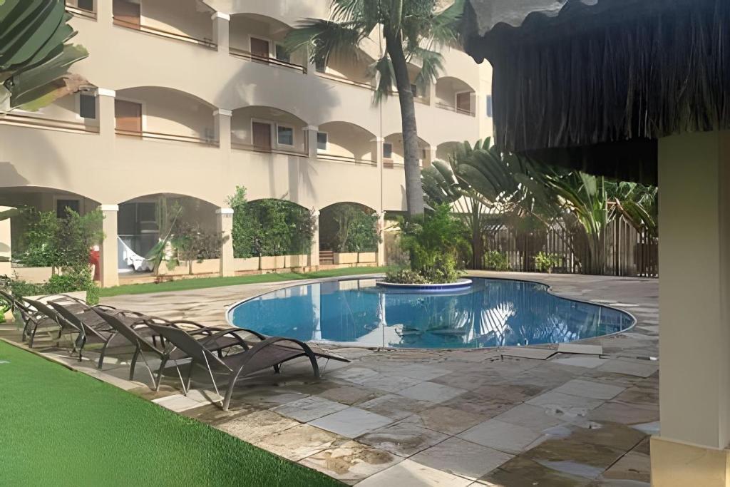 ein Schwimmbad vor einem Gebäude in der Unterkunft Hosts BR - La Serena Suíte Cumbuco in Cumbuco