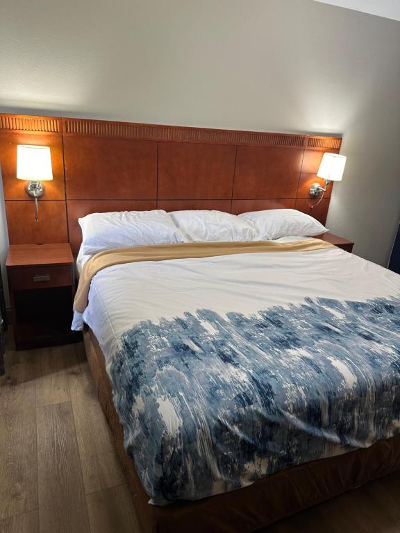 ein großes Bett in einem Hotelzimmer mit zwei Lampen in der Unterkunft Rosewood Inn in Union City