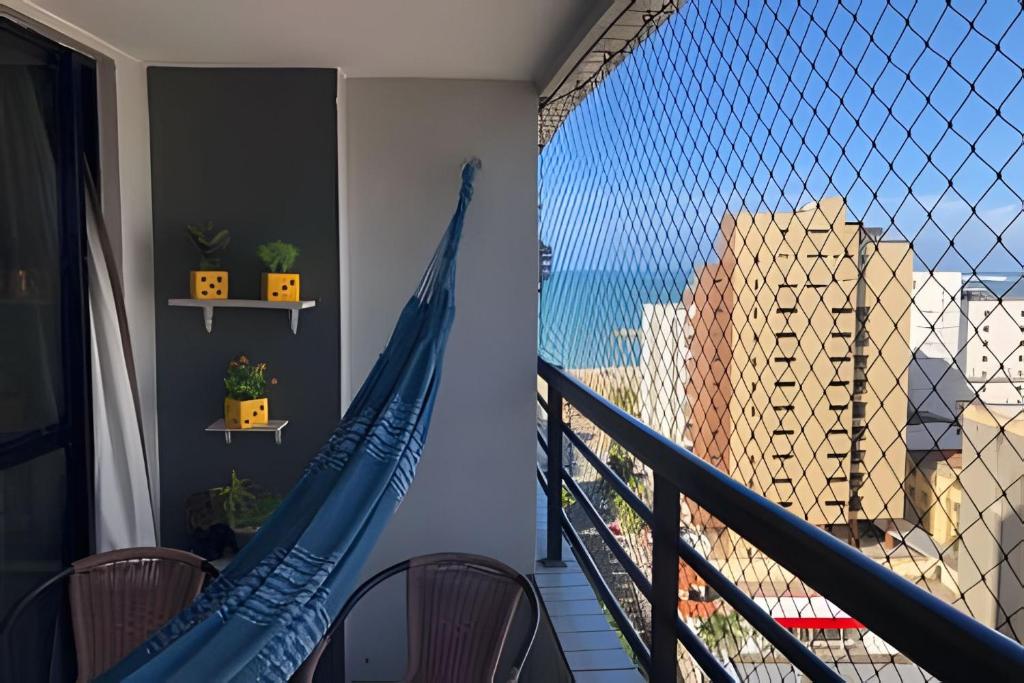 a hammock on a balcony with a view of the ocean at Hosts BR - Flat Vista Mar no Meireles in Fortaleza