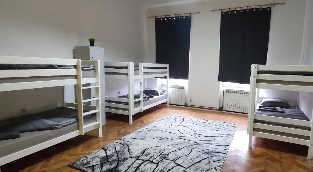 Zimmer mit 4 Etagenbetten und einem Teppich in der Unterkunft Waterfall Hostel in Sarajevo
