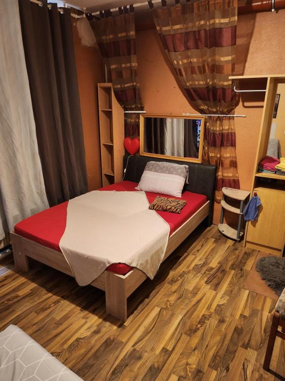 Schlafzimmer mit einem Bett und Holzboden in der Unterkunft Messeblick 1,2 km, Relax- App "Biene und Hummel" romantisch, Doppelzimmer gut & günstig in Hannover
