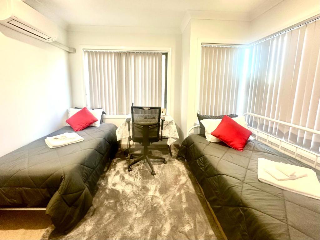 Habitación con 2 camas y ordenador en una mesa en Private Room in Townhouse en Wollongong