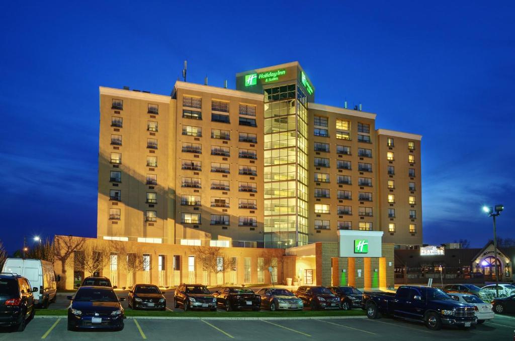 a large building with cars parked in a parking lot at Holiday Inn Hotel & Suites London by IHG in London