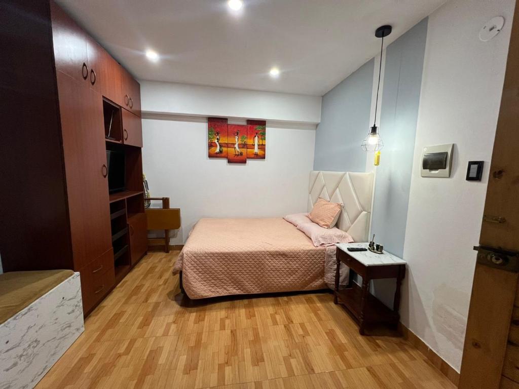 een kleine slaapkamer met een bed en een tafel bij Mini departamento in Trujillo