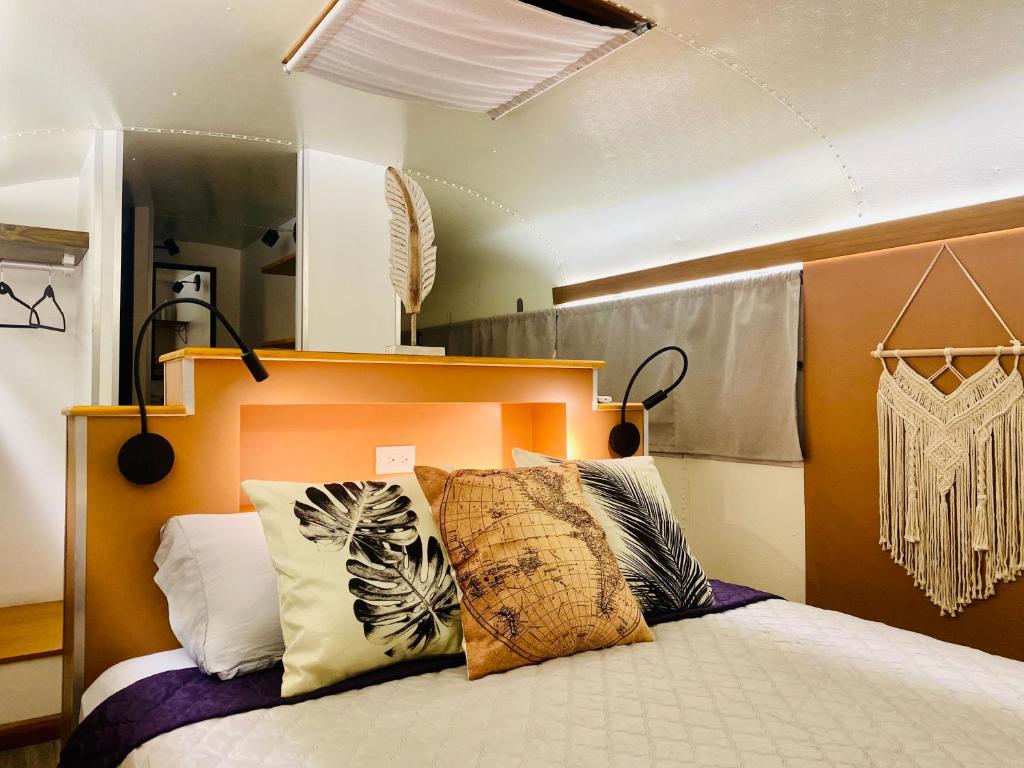 ein Schlafzimmer mit einem Bett mit Kissen darauf in der Unterkunft El Sueño Nómada in Cahuita