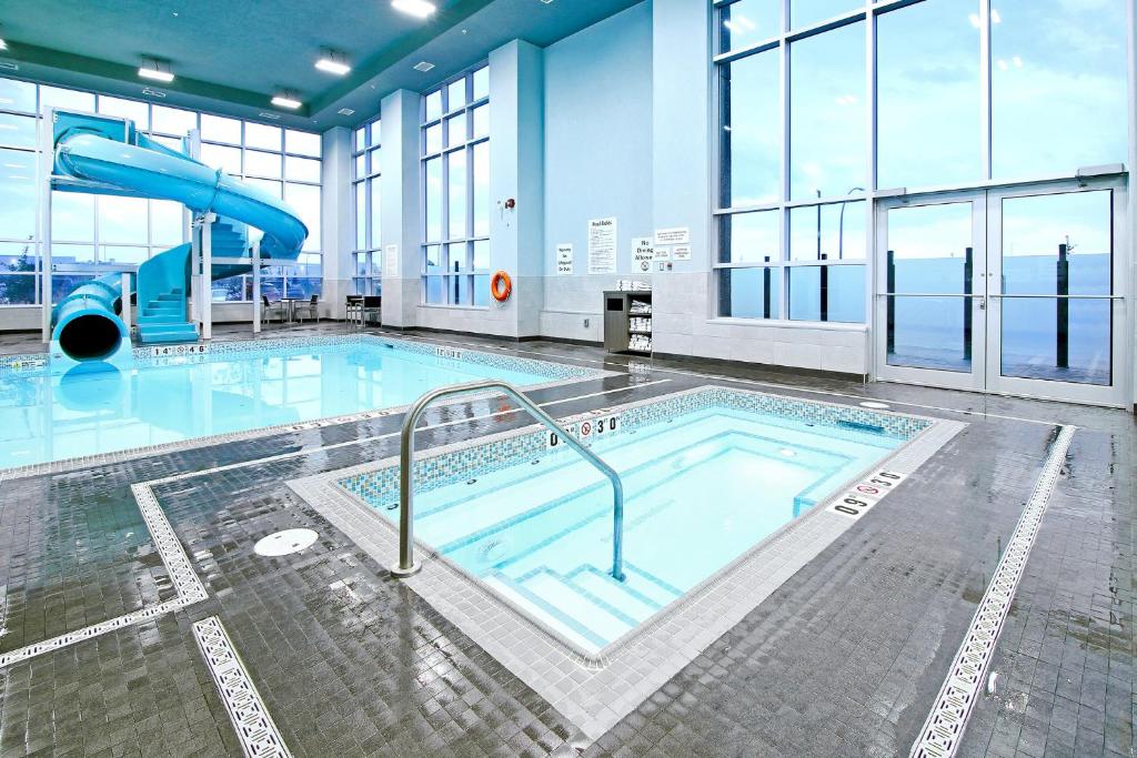 a large swimming pool with a slide in a building at Holiday Inn Hotel & Suites - Calgary Airport North by IHG in Calgary