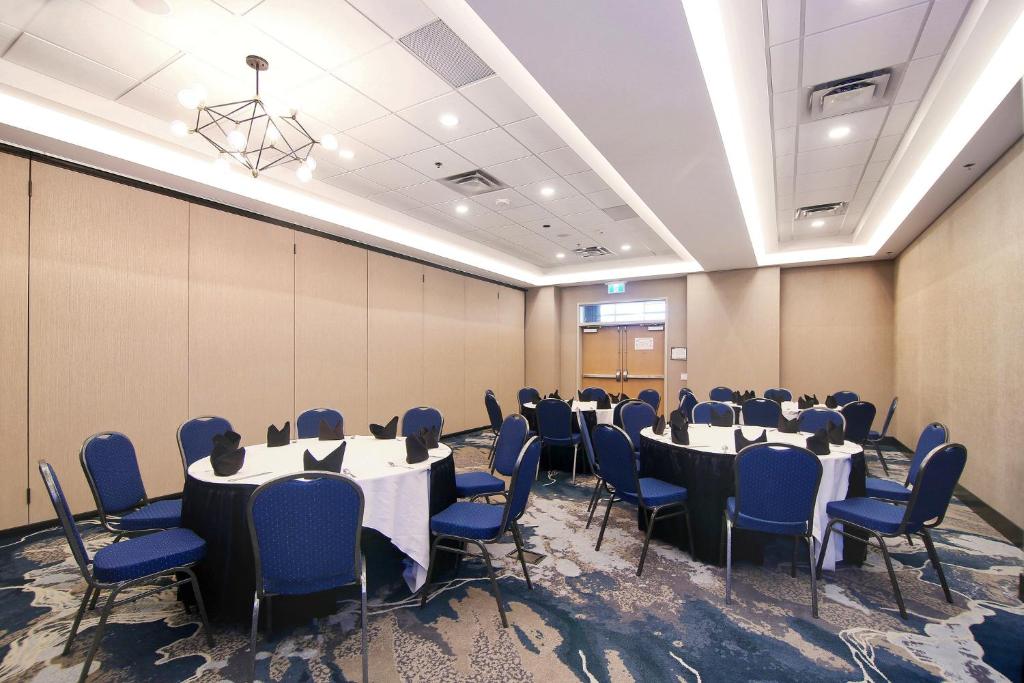 a conference room with tables and chairs in it at Holiday Inn Hotel & Suites - Calgary Airport North by IHG in Calgary