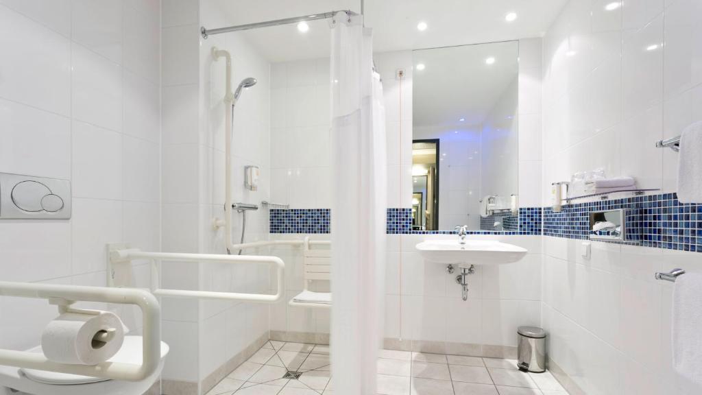 a white bathroom with a sink and a shower at Holiday Inn Express Singen, an IHG Hotel in Singen