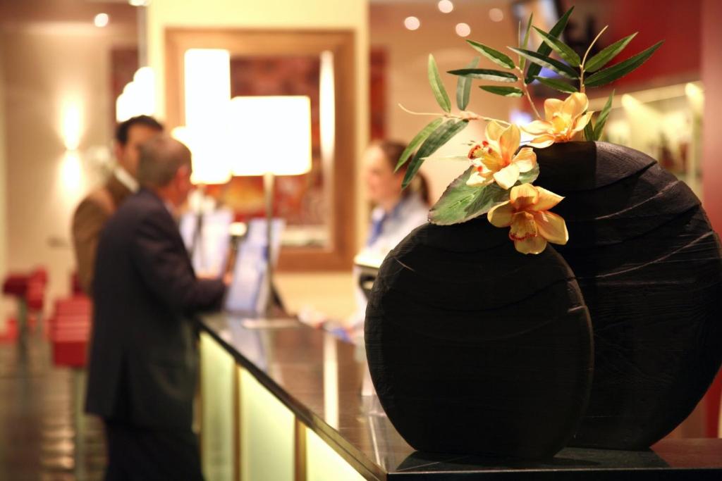 a black vase with flowers on top of a counter at Holiday Inn Express Singen, an IHG Hotel in Singen