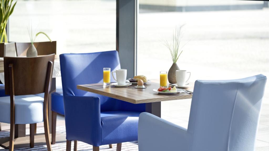 a dining room with blue chairs and a table at Holiday Inn Express Singen, an IHG Hotel in Singen