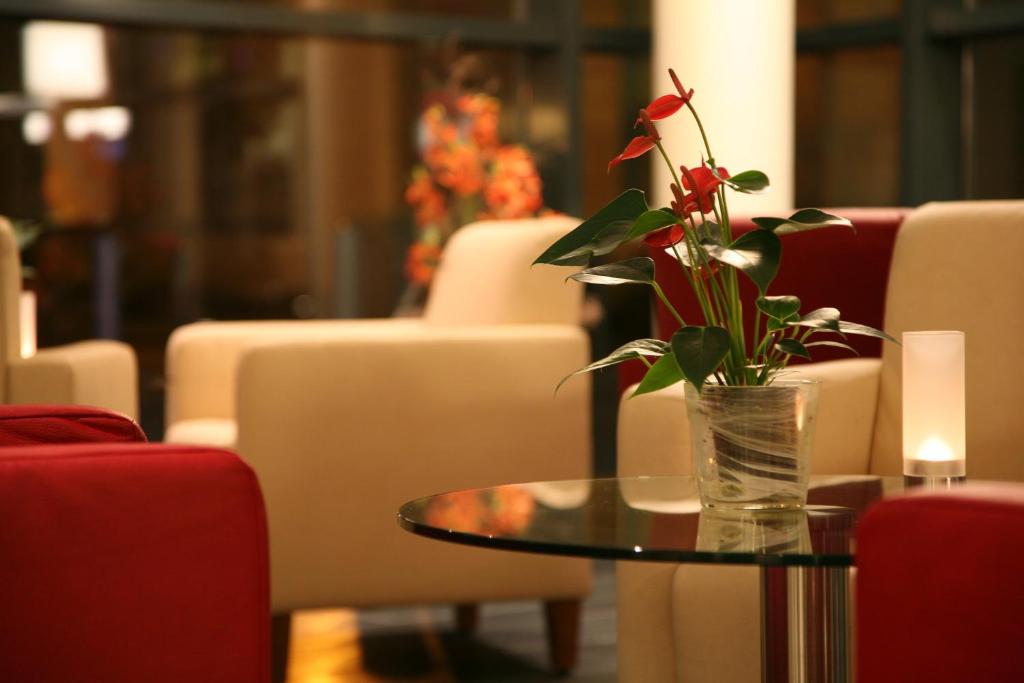 a glass vase with a flower on a table at Holiday Inn Express Singen, an IHG Hotel in Singen
