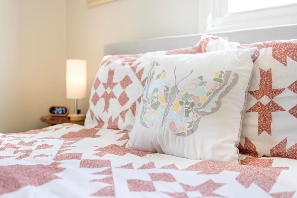 Schlafzimmer mit rosa und weißen Kissen auf dem Bett in der Unterkunft 3BR Home Near Historic Downtown Jonesborough in Jonesborough