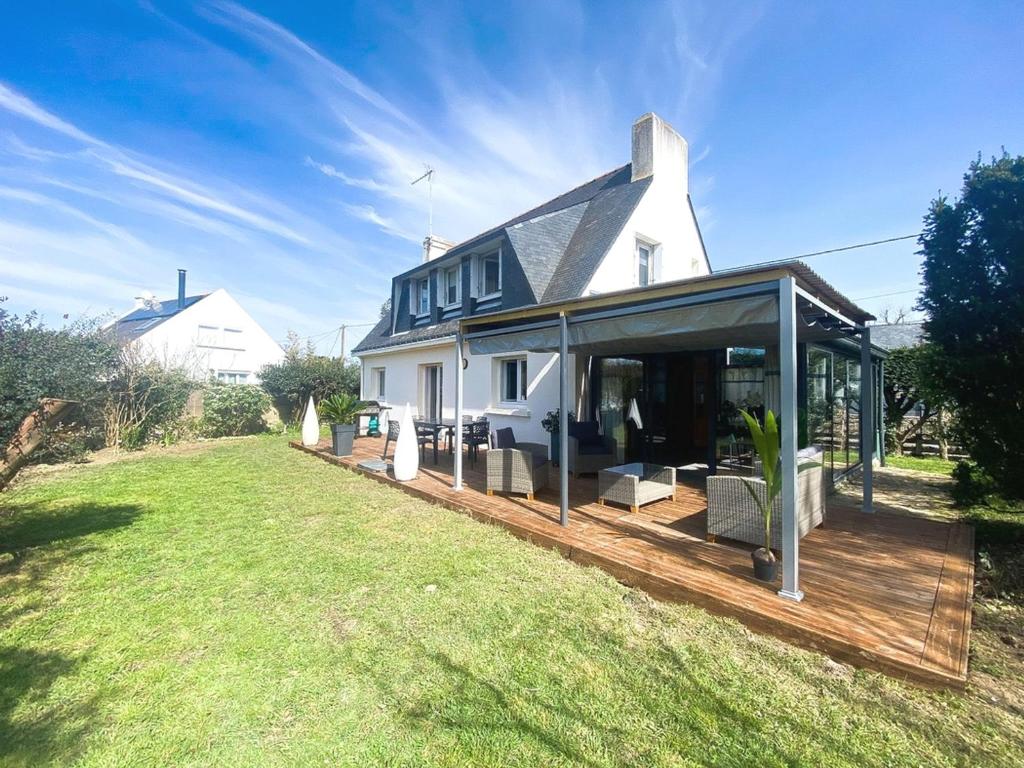 a white house with a deck and a house at Maison Saint-Gildas-de-Rhuys, 4 pièces, 6 personnes - FR-1-639-112 in Saint-Gildas-de-Rhuys