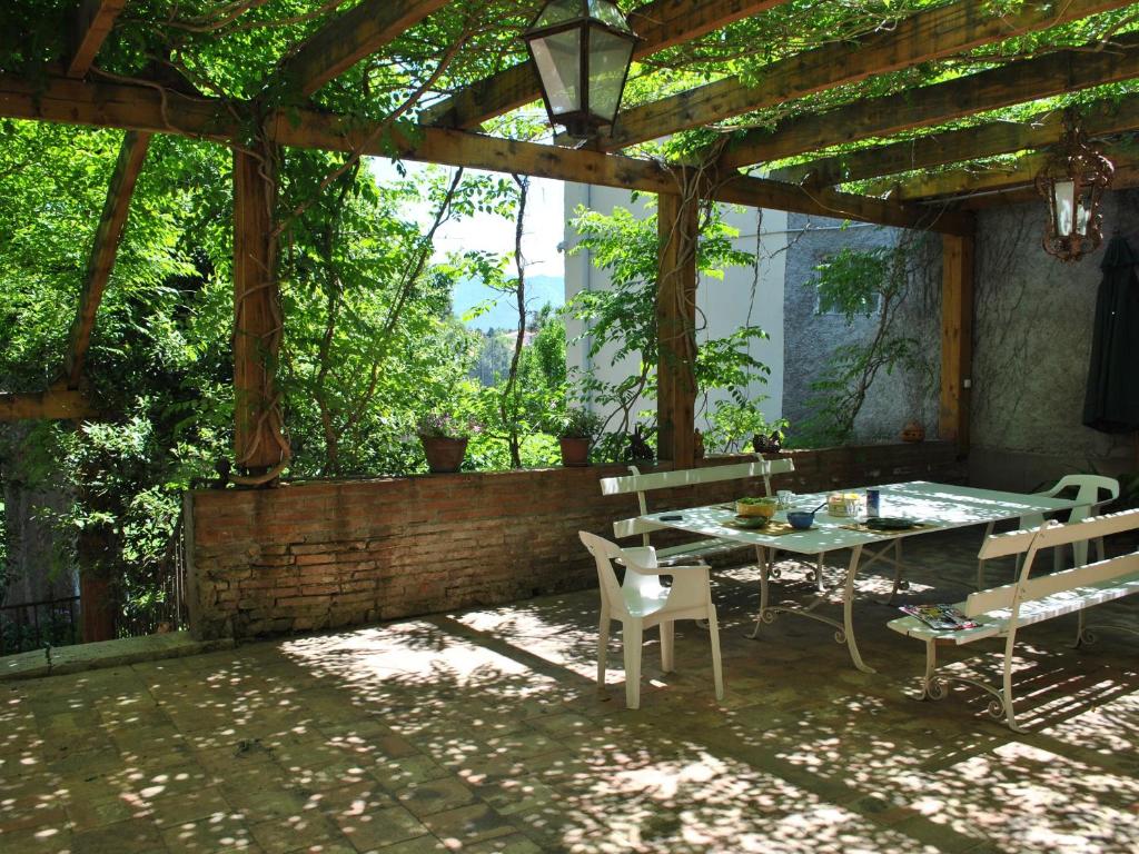 um pátio com uma mesa e cadeiras sob uma pérgola em Maison Palau-del-Vidre, 7 pièces, 12 personnes - FR-1-776-88 em Palau-del-Vidre