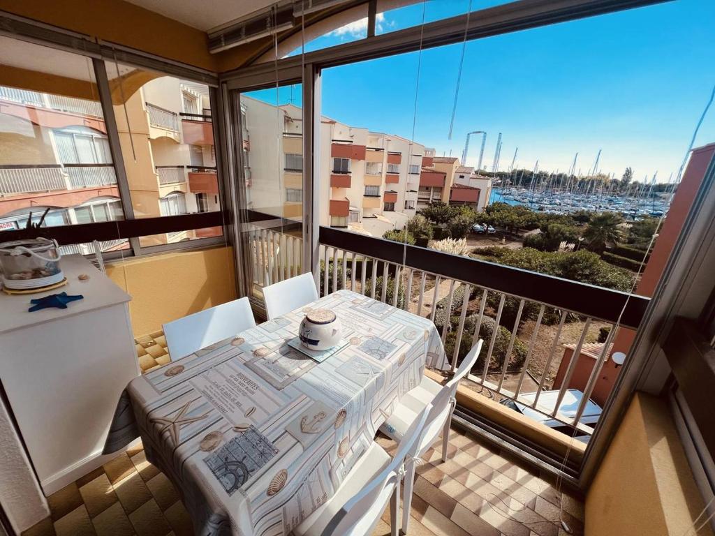 un balcon avec une table et des chaises et une vue dans l'établissement Cap d'Agde: Apt proche plage et port, parking privé - FR-1-723-151, au Cap d'Agde