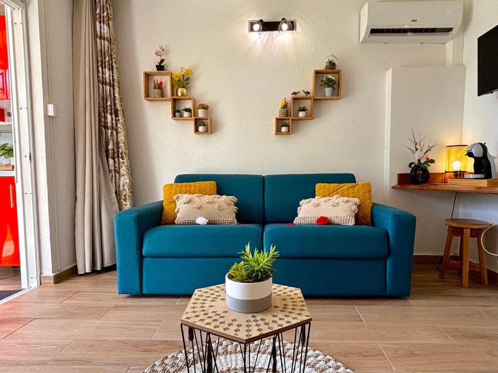 - un canapé bleu dans le salon avec une table dans l'établissement La Saranah - Blue Dream, Piscine, Plage, à Grand-Bourg