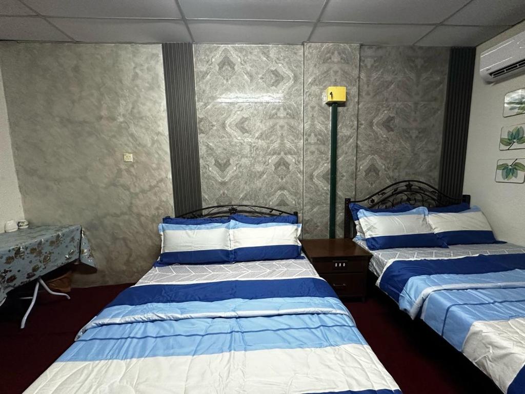 twee bedden in een kamer met twee bedden sidx sidx sidx bij Bilik Bajet BDS in Temerloh