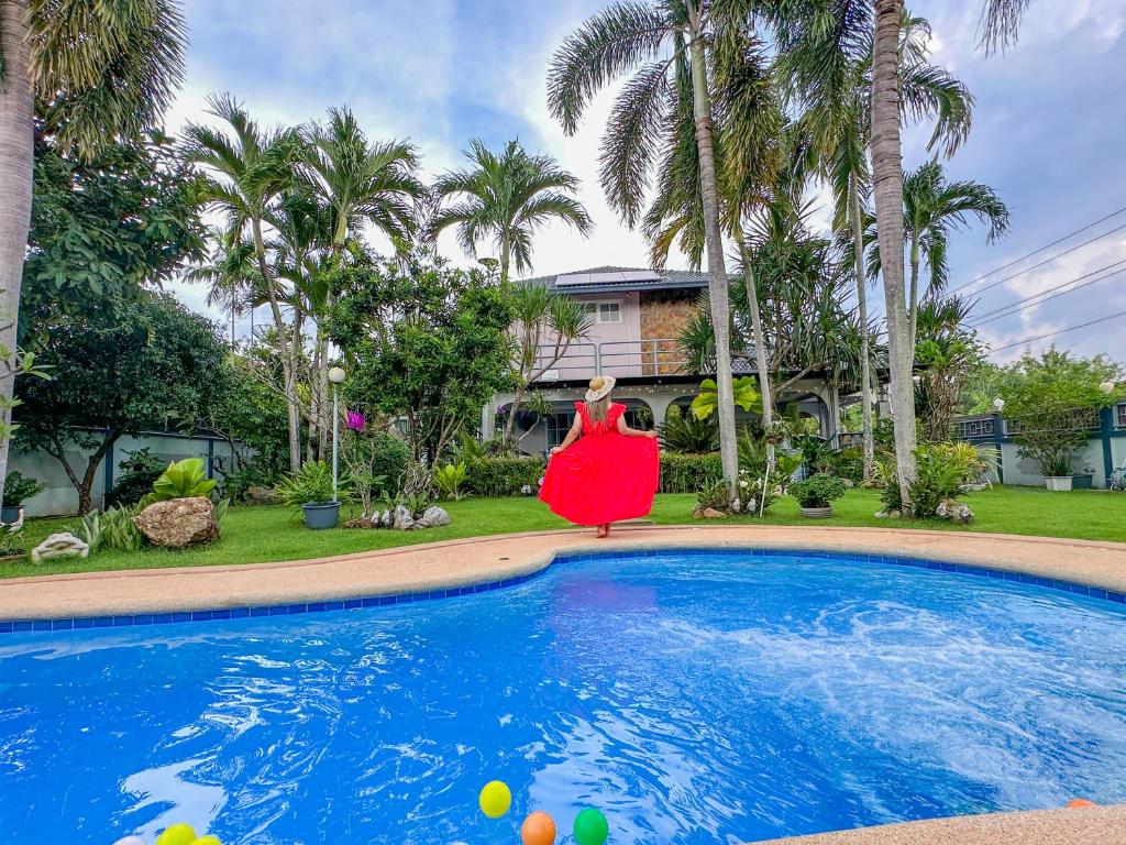 una estatua de una mujer con un vestido rojo de pie junto a una piscina en Let's Chill Pool Villa Pattaya Najomtien42 and Sattahip, en Ban Tao Than