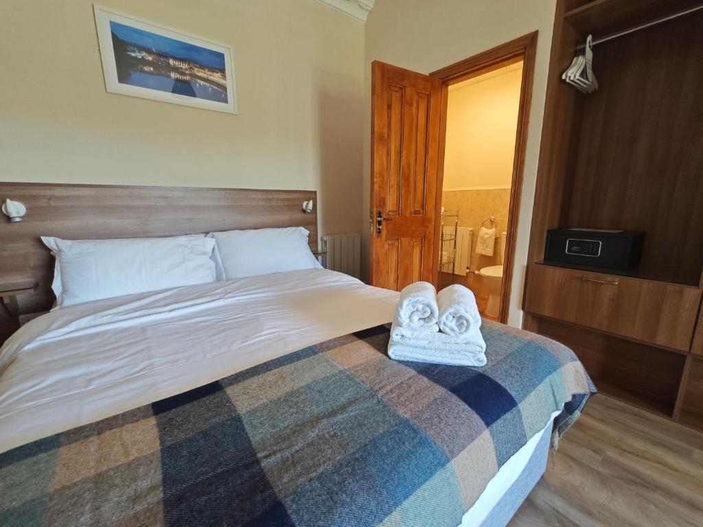 a bedroom with a bed with towels on it at Mountain View Accommodation in Donegal